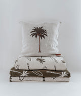 A stack of DUVET COVERS with palm trees on them from Bengali Collections.