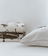 A set of JERSEY COTTON SHEET - SURFING PALM pillows from Bengali Collections with leaves on them.