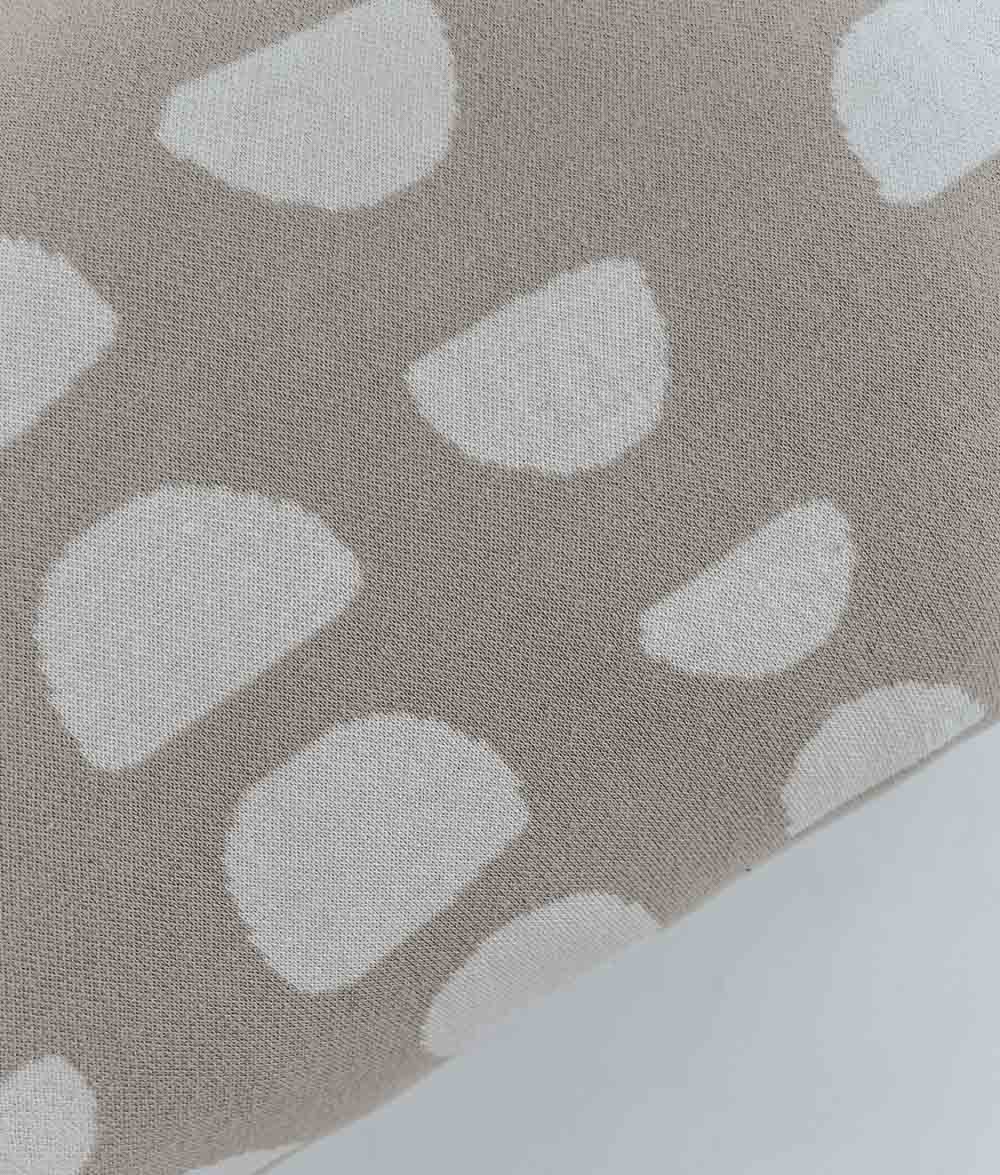 Close-up of the ivory moon phase print on the oatmeal Moon Phase jersey cotton fitted sheet