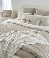 Bed styled with a salty days cushion, palm print bedding and the dune quilt