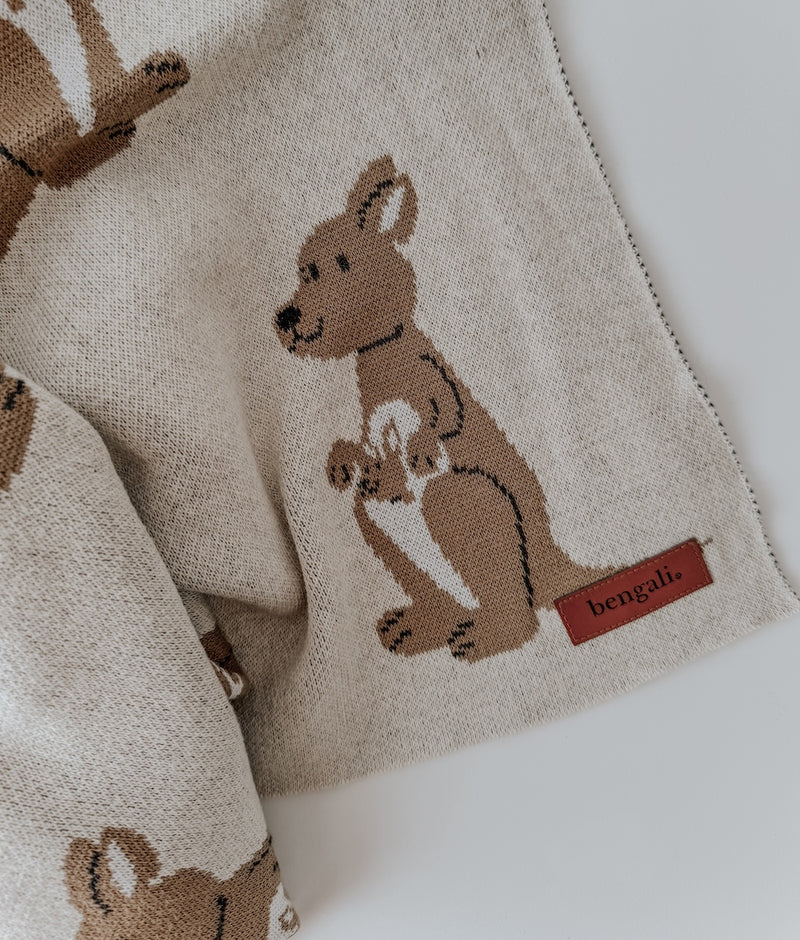 Close-up of a kangaroo and joey knitted into the natural marle Kangaroo baby blanket, with leather label