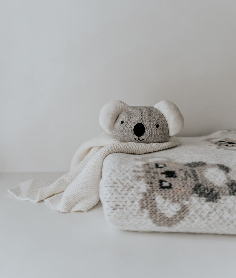 Koala baby comforter snuggly resting on a folded koala knit blanket