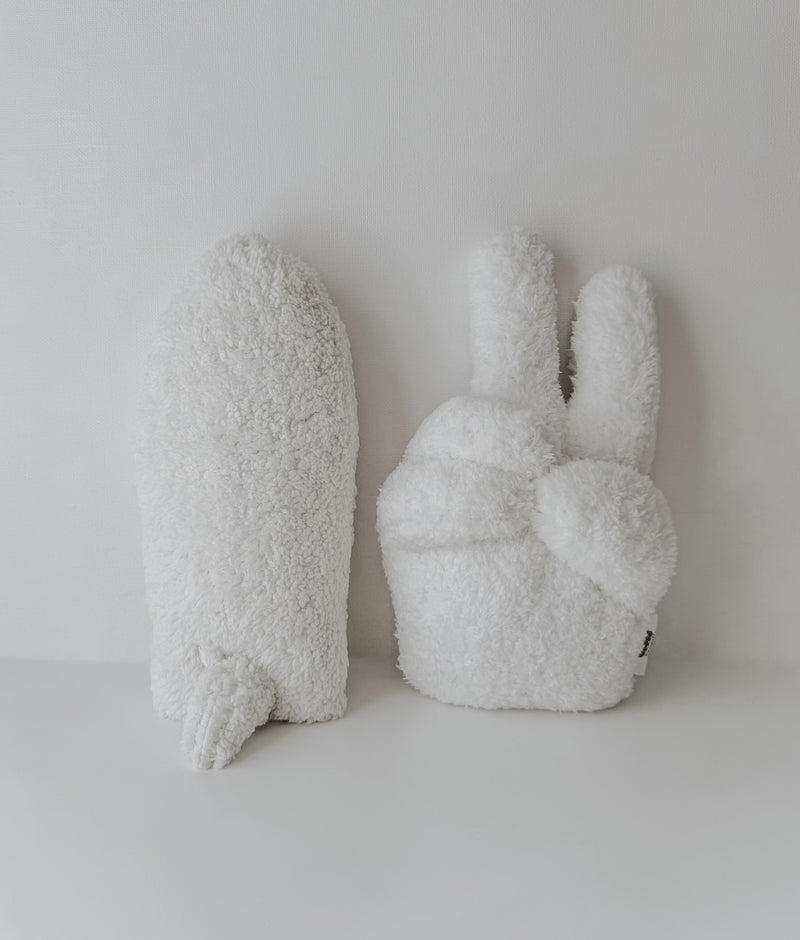 Ivory Peace Sherpa kids cushion standing next to a second Sherpa cushion on a white backdrop