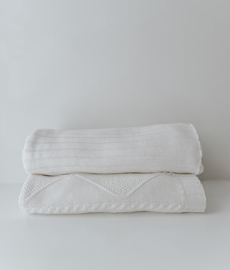 Ivory Corduroy lounge throw stacked above the Ivory Diamante throw, both folded on a white backdrop