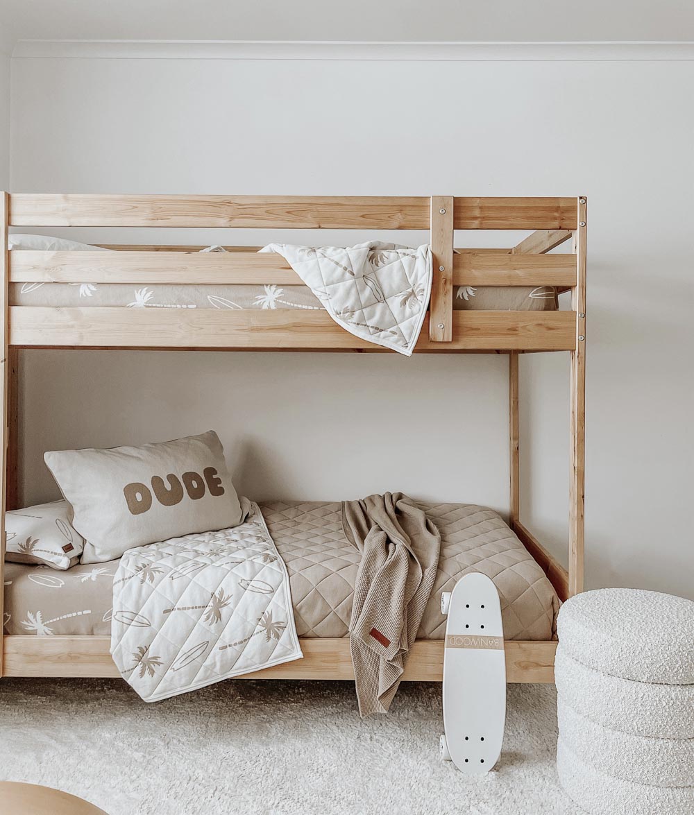 Timber bunk bed with a sand Surfing Palm fitted sheet, Surfing Palm quilt, DUDE pillowcase and a mini skateboard