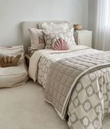 Bedroom with a shell cushion and shell check quilt layered over the dune quilt