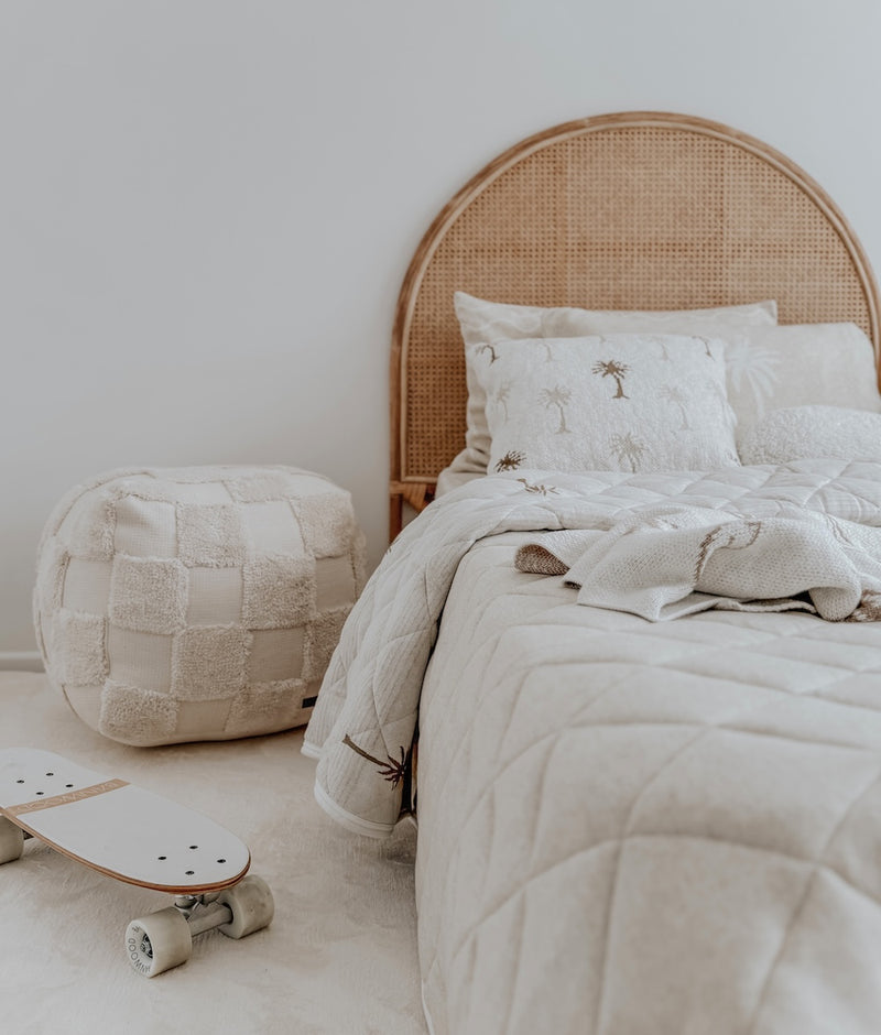 Kids bed with a rattan bedhead, Palma palm cushion cover, quilted bedding, pouf and skateboard