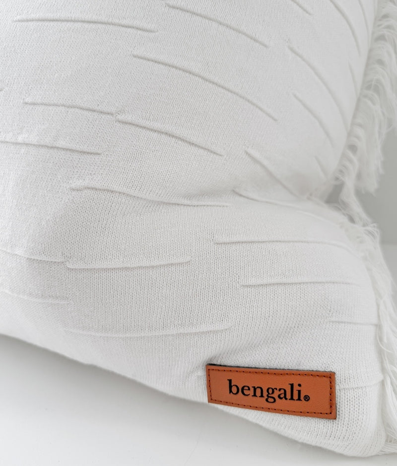 Close-up of the Ivory Flurry cushion cover's fringed corner and leather Bengali label