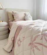 Girls bedroom with a pink and cream quilted bed, a bunny soft toy and boucle side table