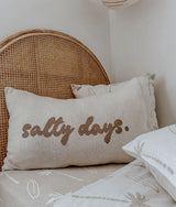 Salty days lumbar cushion in front of a dune palm print pillow on a rattan bed