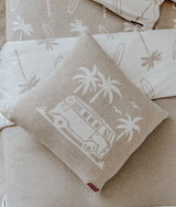 Dune campervan cushion resting against palm print pillows on the dune bedding