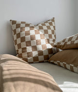 Khaki gingham check euro and pillow propped above the plain khaki duvet cover
