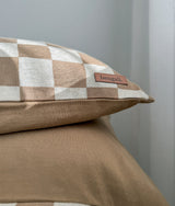 Close-up of the khaki gingham euro pillowcase showing the leather Bengali tab on its edge