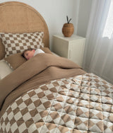 Rattan bed dressed with the khaki gingham pillowcase and the matching quilt