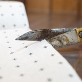 A pair of scissors cutting a Good Change reusable bamboo towel.