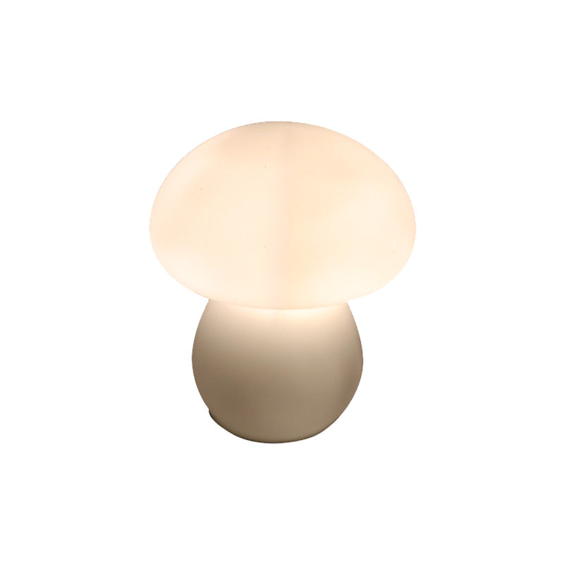 The mushroom lamp lit, warm light glowing through the white glass dome