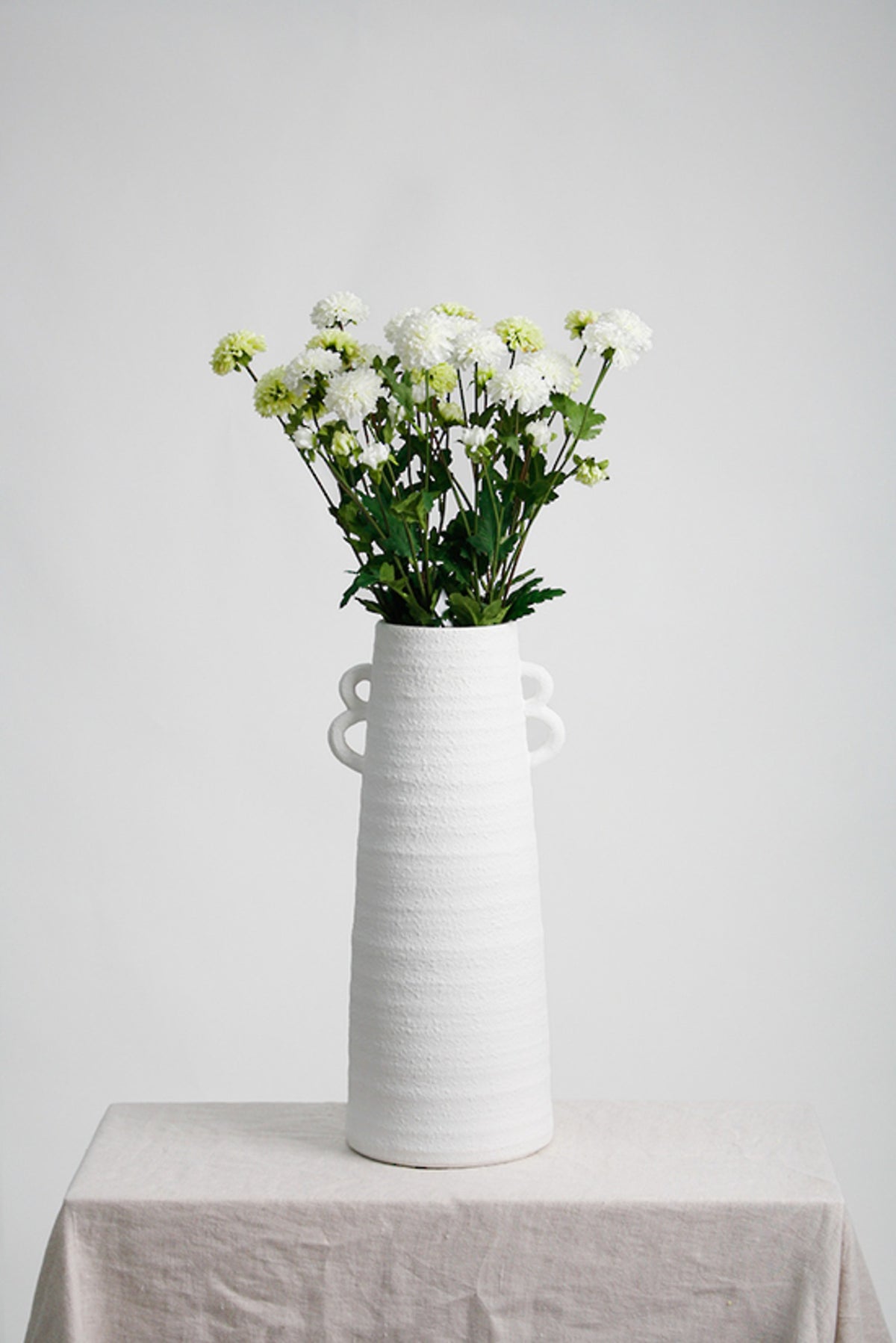 Pompom mum spray faux stems in white and green shown side by side, 68cm
