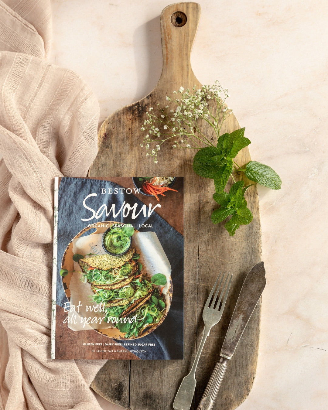 Savour Bestow recipe book styled on a wooden board with fresh herbs