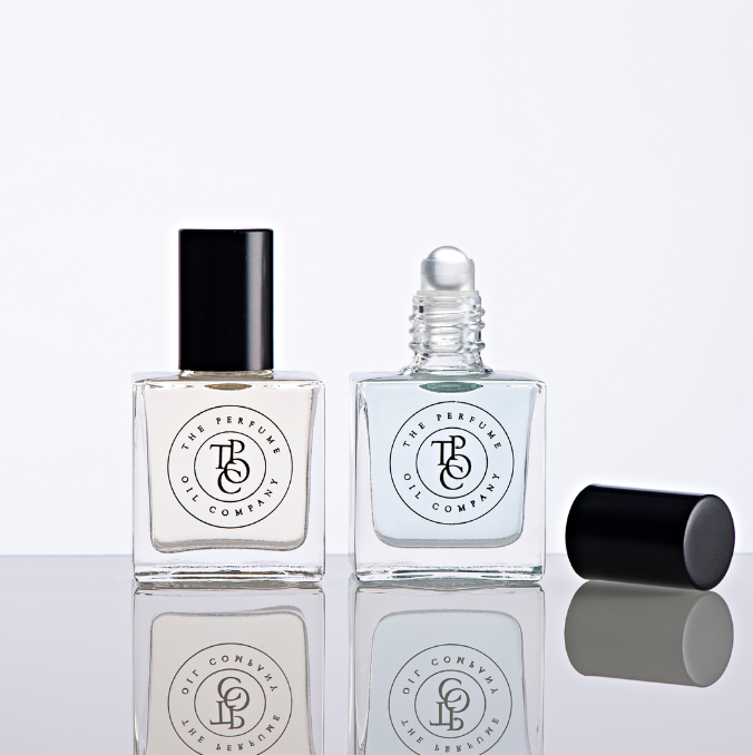 Two bottles of MIDNIGHT perfume oil by The Perfume Oil Company on a white surface