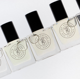 Five bottles of GHOST perfume oil, inspired by Mojave Ghost (Byredo), adorn a white surface.