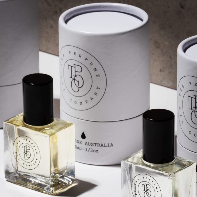 Three bottles of MIDNIGHT perfume oil by The Perfume Oil Company displayed on a white surface