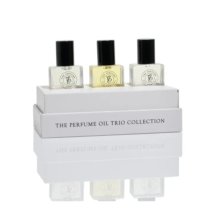 Three roll-on perfume oil bottles standing on the trio collection gift box