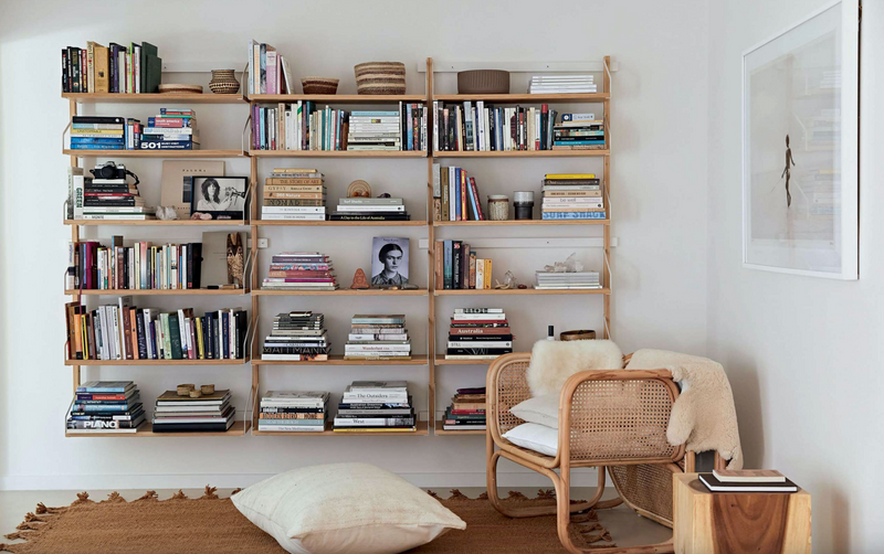 A creative community room with Home By The Sea bookshelves and a chair in Byron Bay.