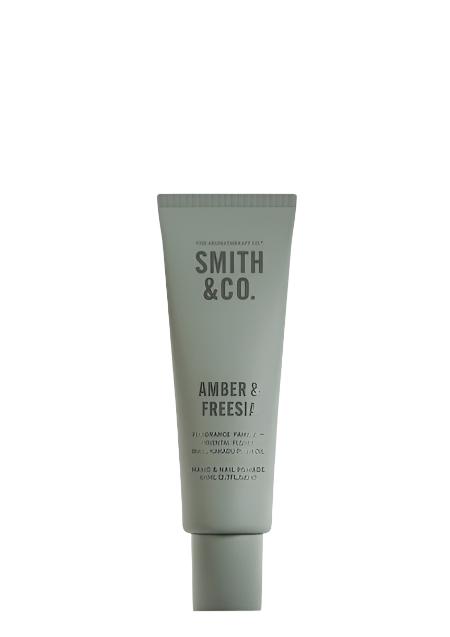 Smith & Co. Amber & Freesia hand and nail pomade in a sage green tube on a white background