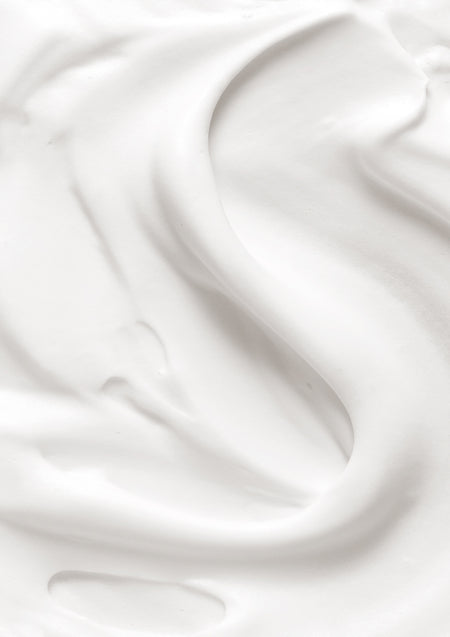 Close up of thick white hand cream swirled in soft folds