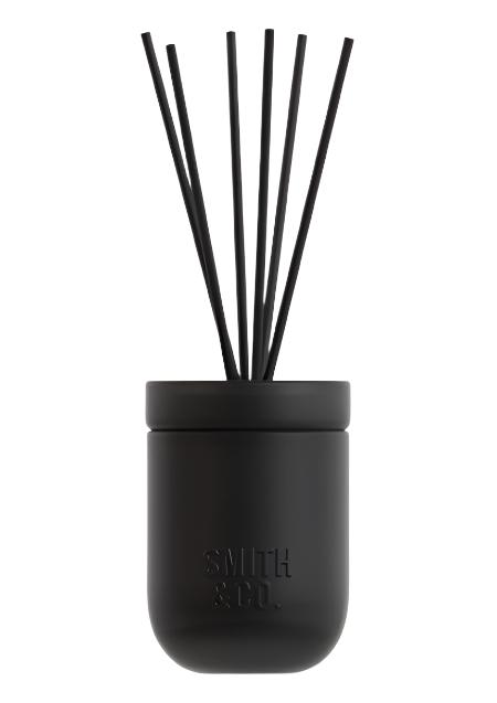 Smith & Co. Tabac & Cedarwood reed diffuser in a matte dark vessel with black reeds on white