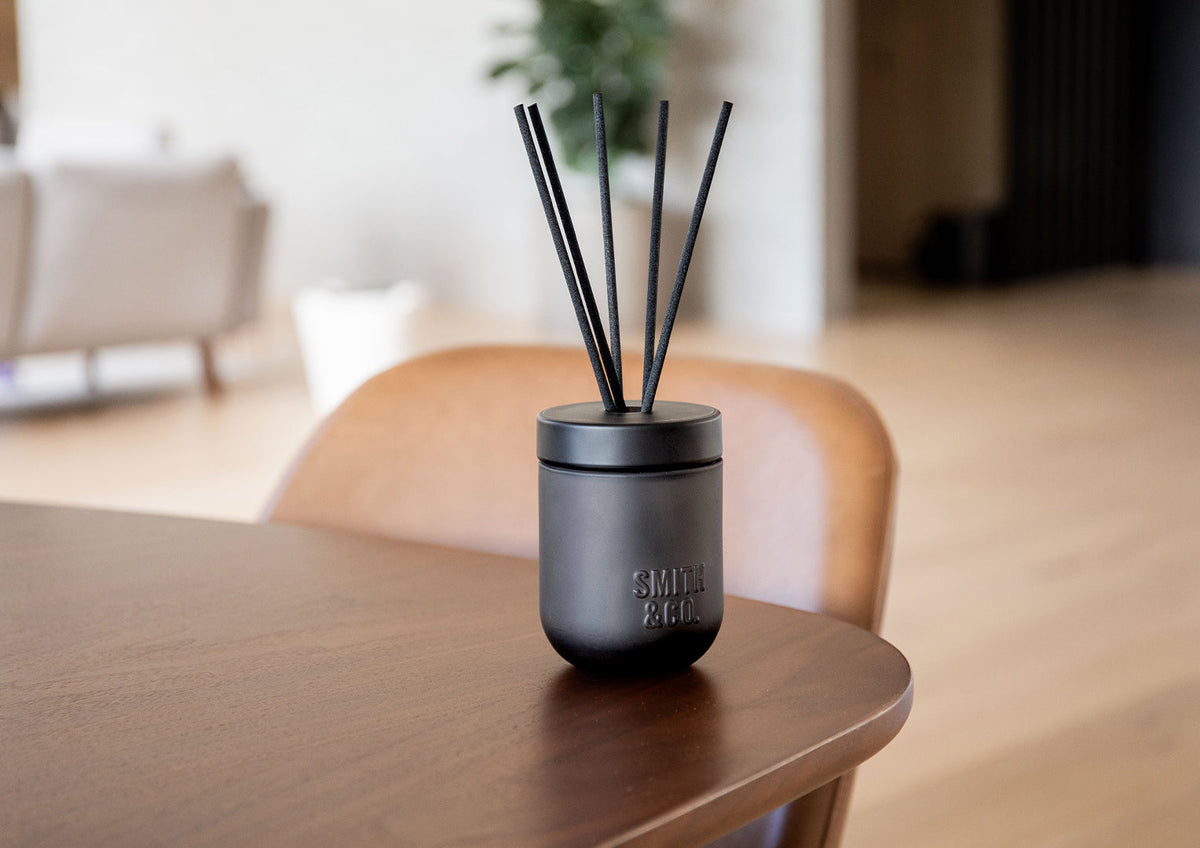 Smith & Co. diffuser on the edge of a dark timber table in a bright living space