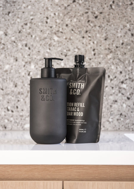 Smith & Co. bottle and refill pouch on a white vanity against terrazzo, with timber drawers below