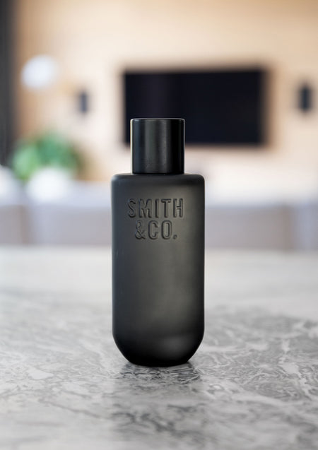 Black Smith and Co room spray on a grey marble surface in a living room