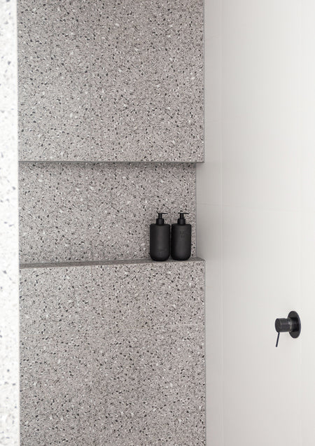 Smith & Co. bottles on a terrazzo shelf in a tiled shower, wide view
