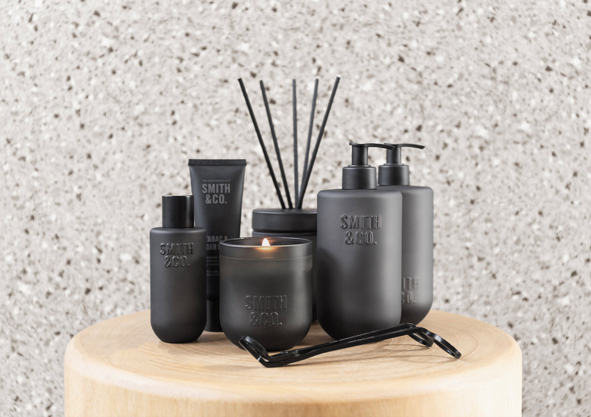 Smith & Co. wash with a matching diffuser and bottles on a timber stool against terrazzo