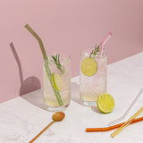 Two Sucker sustainable glasses of iced tea with lime slices and Reusable Glass Drinking Straws - Transparent / Multi-coloured.