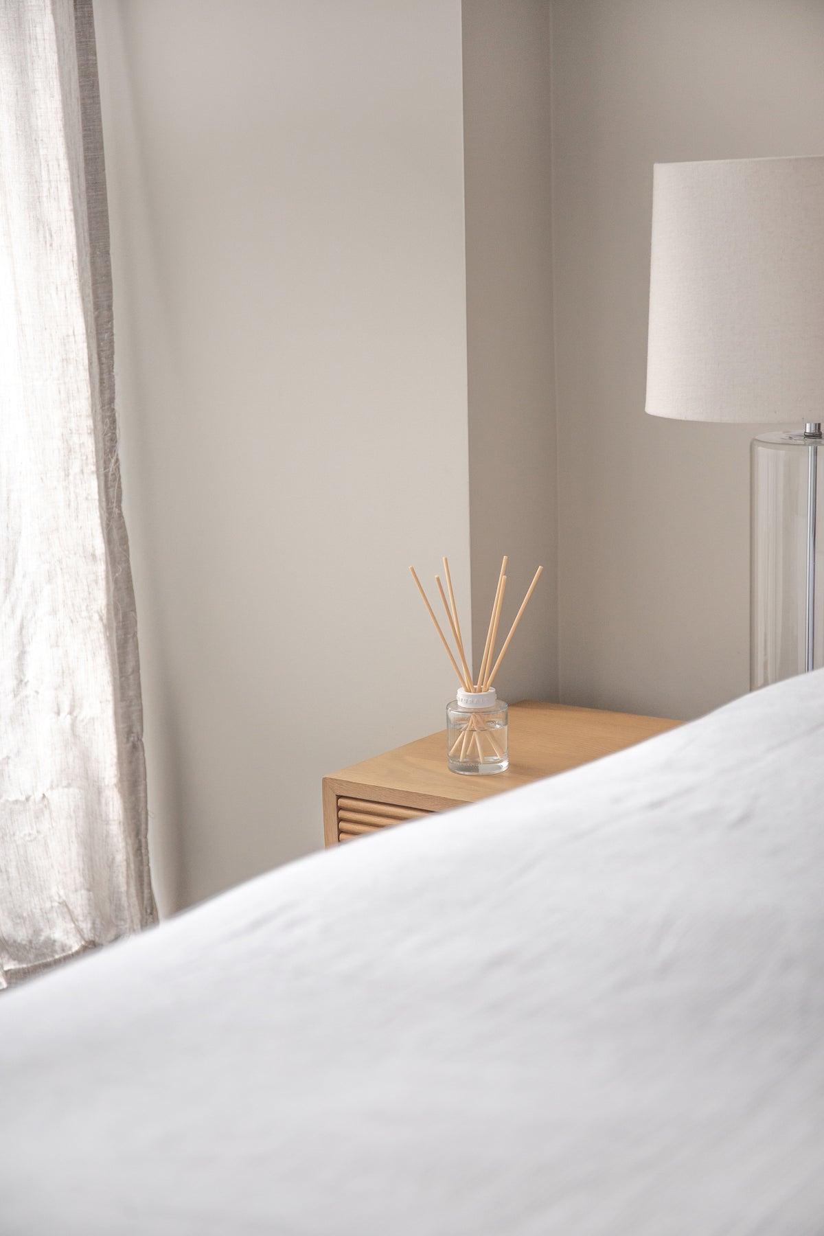 Bedroom with the Naturals diffuser on a timber bedside table beside a lamp