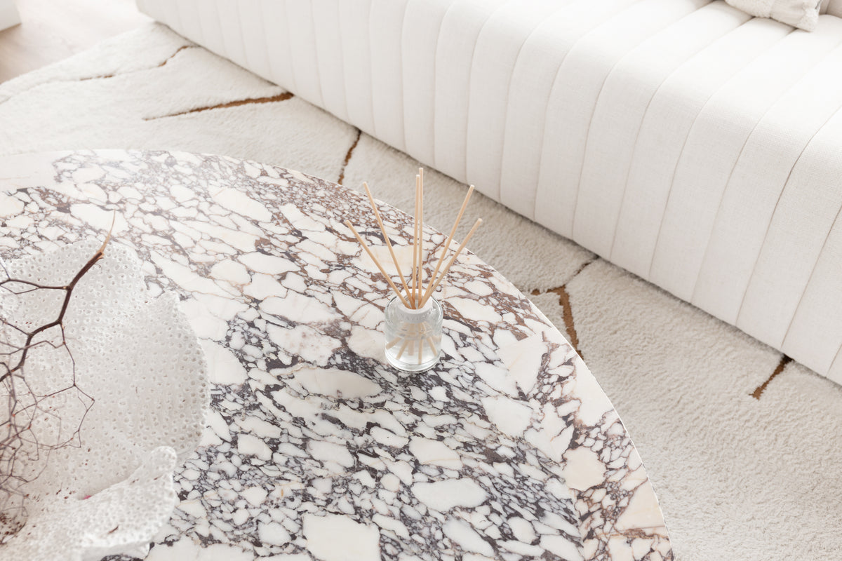 Looking down on the Naturals diffuser on a veined marble table beside a fluted sofa