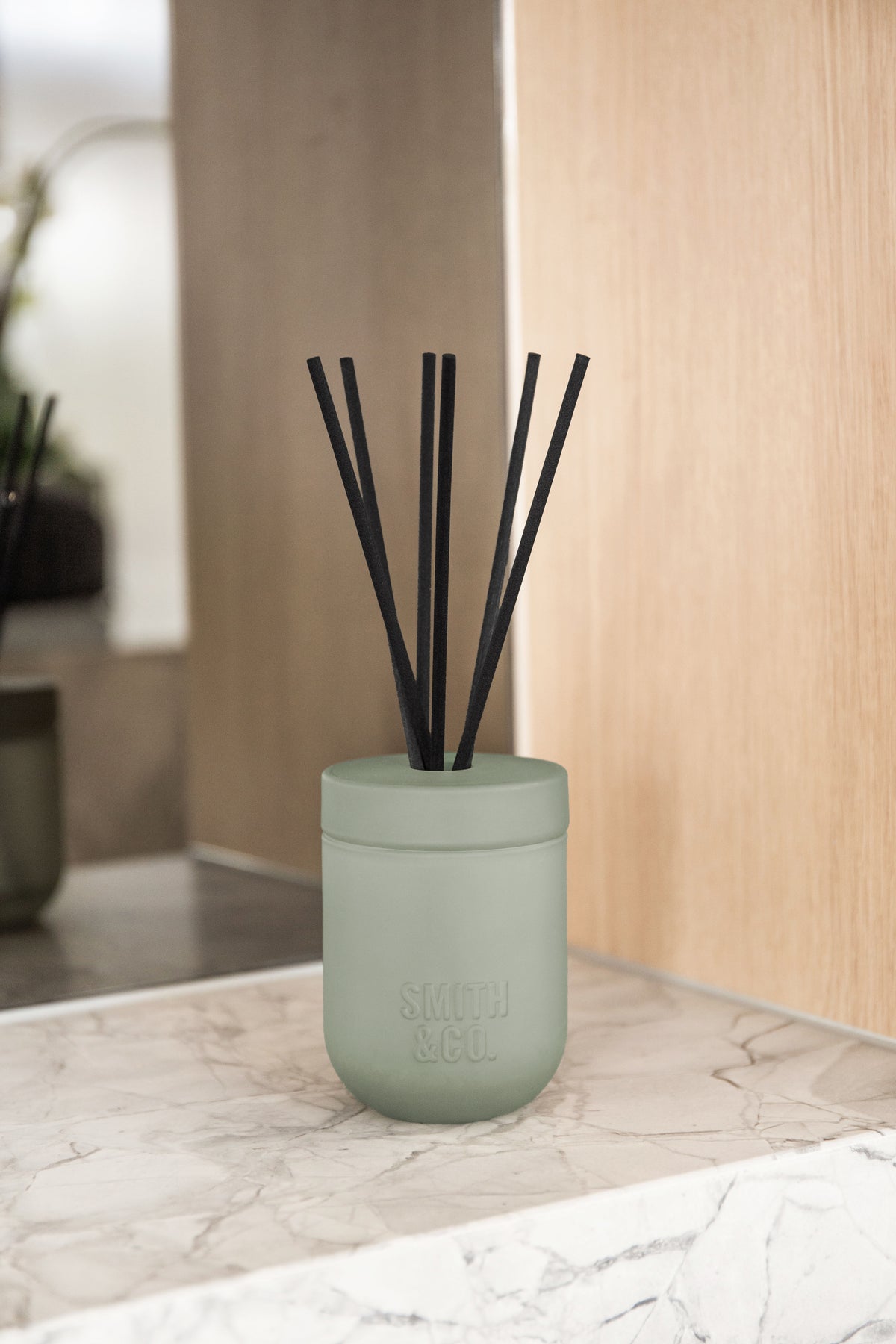 Smith and Co reed diffuser on a marble ledge in front of a pale timber panel