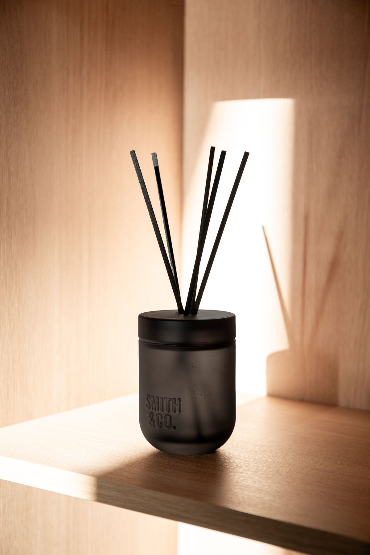 Smith & Co. diffuser on a timber shelf lit by sunlight from a window