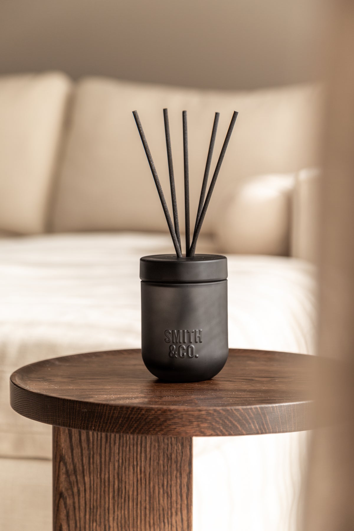 Smith & Co. diffuser on a timber side table in front of a cream sofa