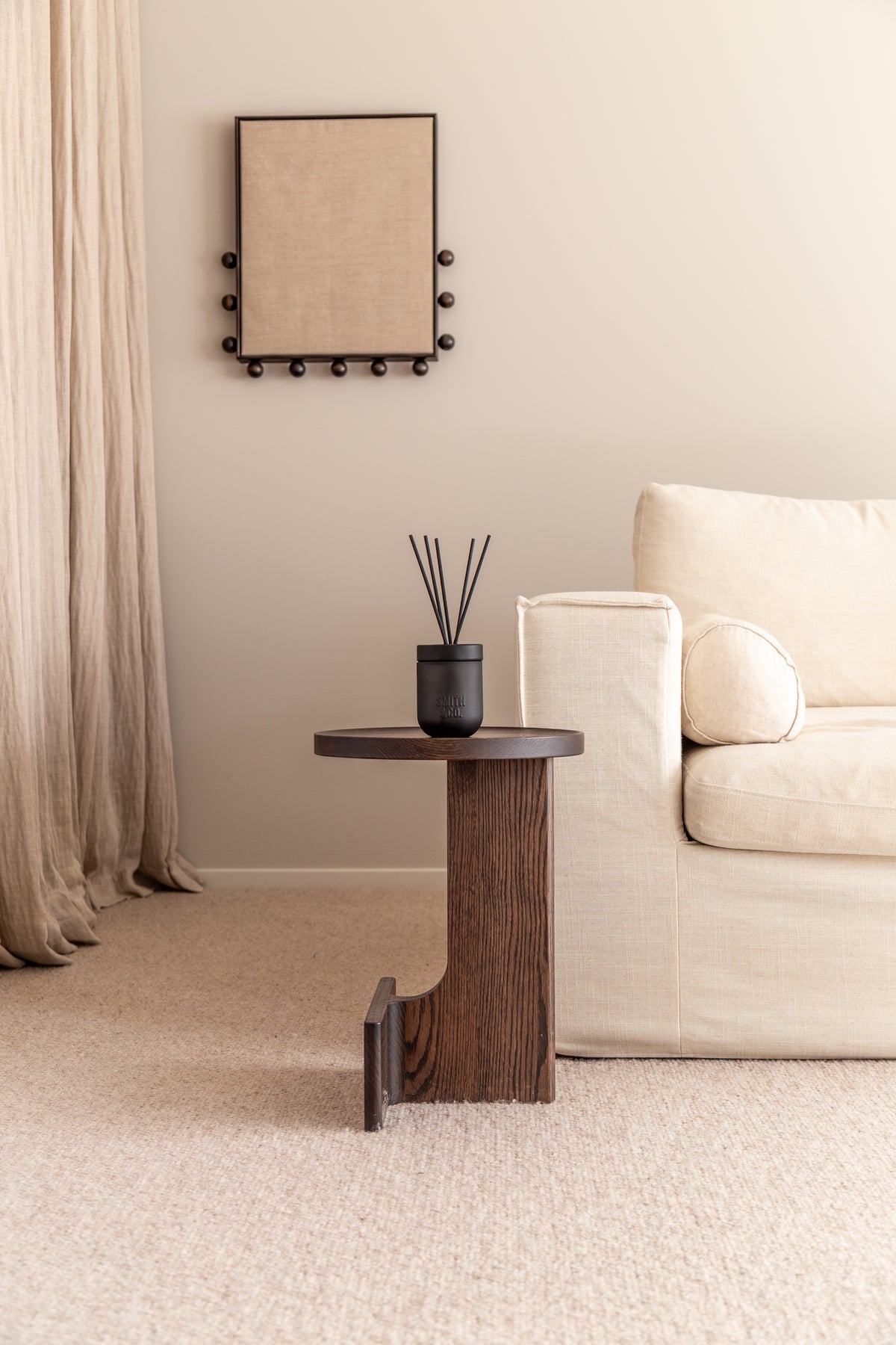 Wide view of a cream living room with the Smith & Co. diffuser on a timber side table