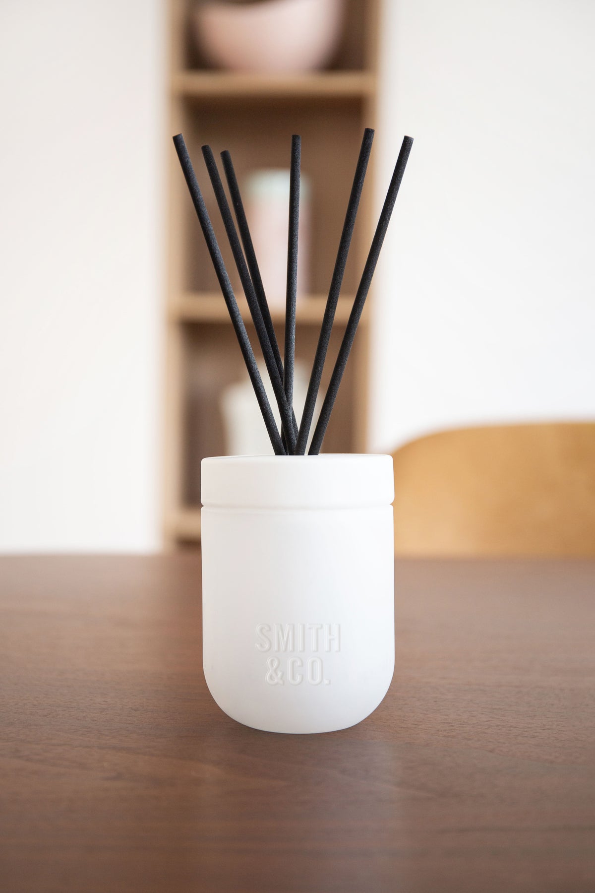 Smith and Co white diffuser on a dark timber table in a softly lit room
