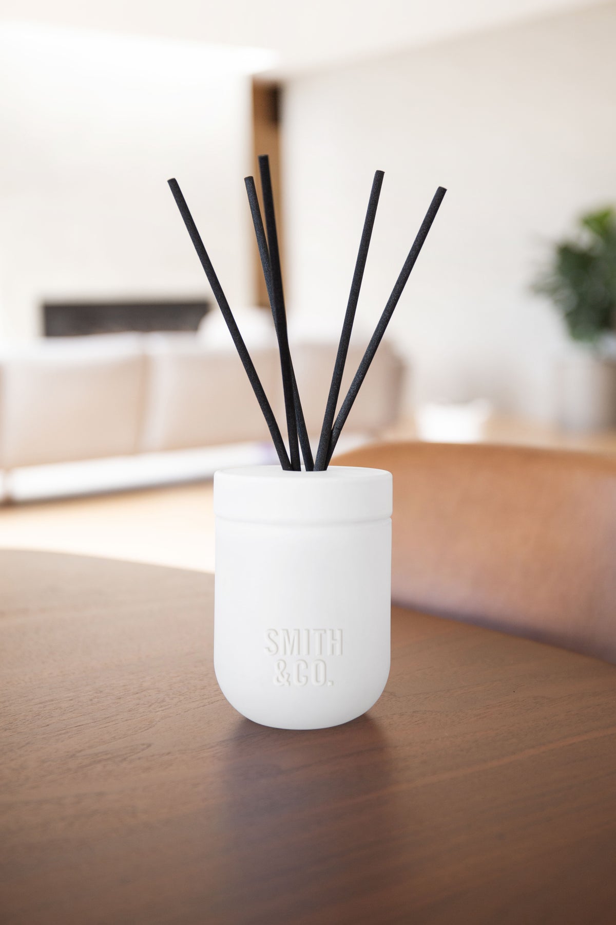 White Smith and Co diffuser on a dark timber table in a bright living room