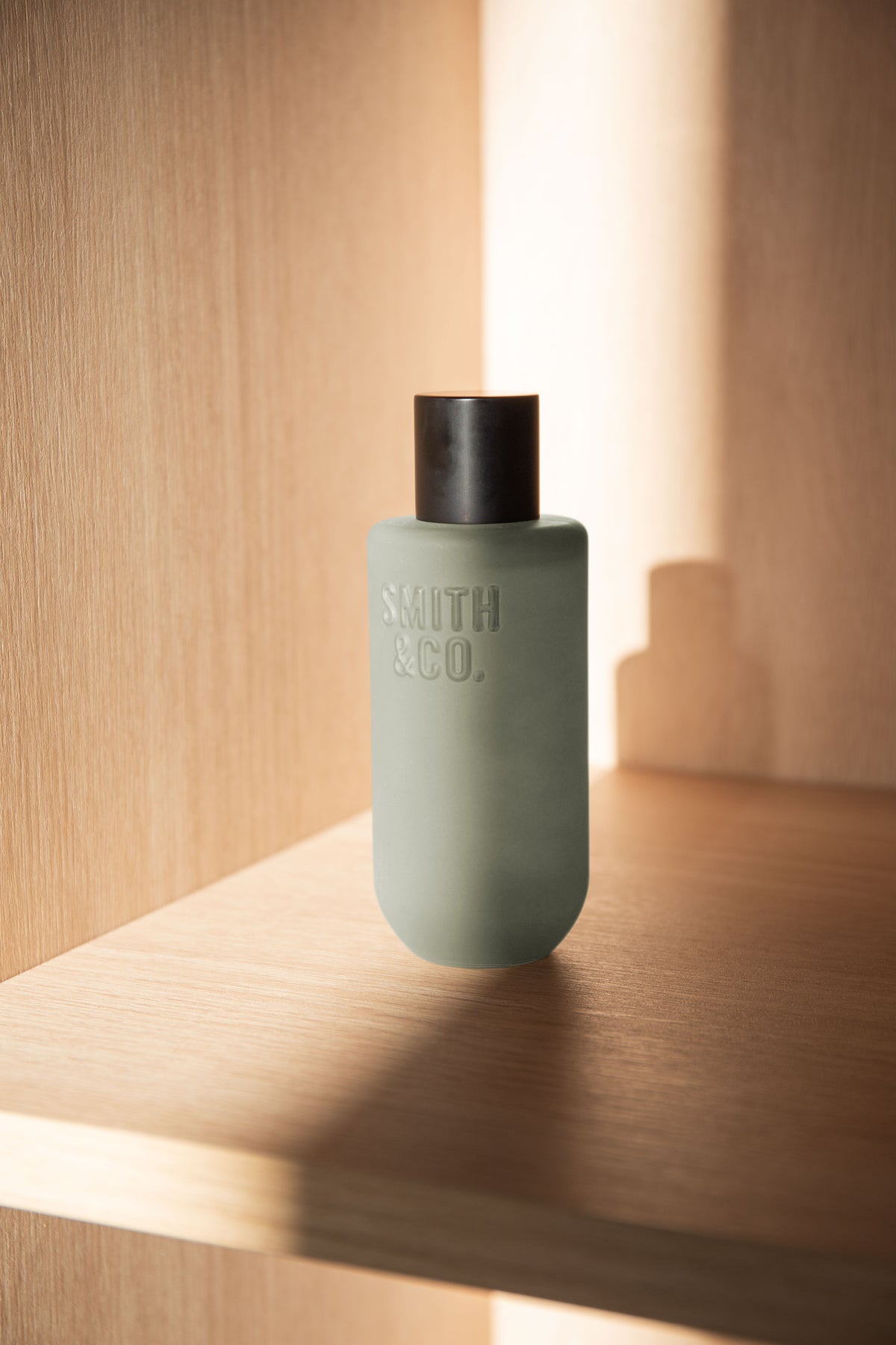 Portrait crop of the room spray on a sunlit oak shelf with a stepped shadow behind