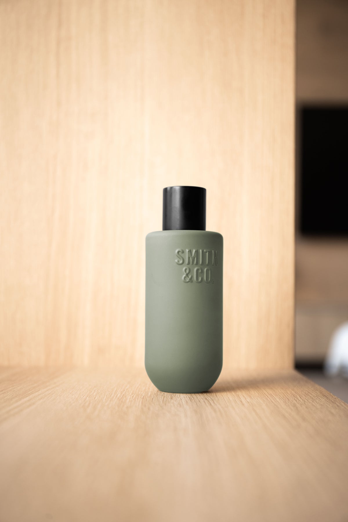 Smith & Co. room spray centred against oak panelling on a light oak surface