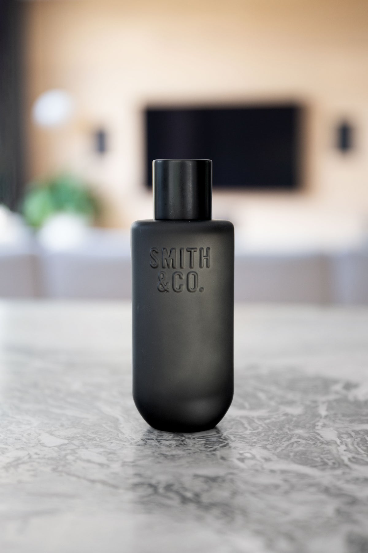 Black Smith and Co room spray on grey marble with a living room blurred behind