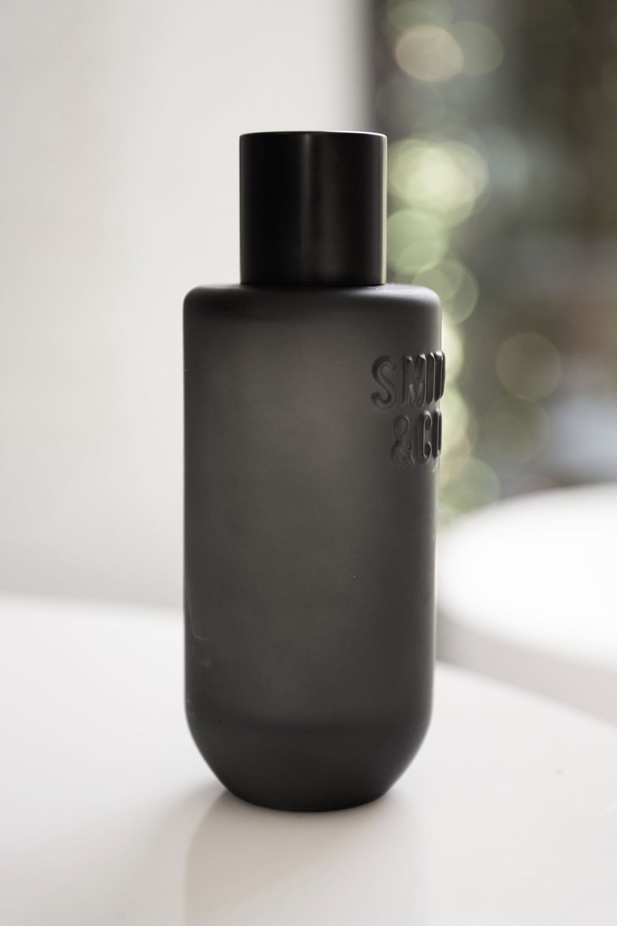 Black Smith and Co room spray on white with soft window light behind