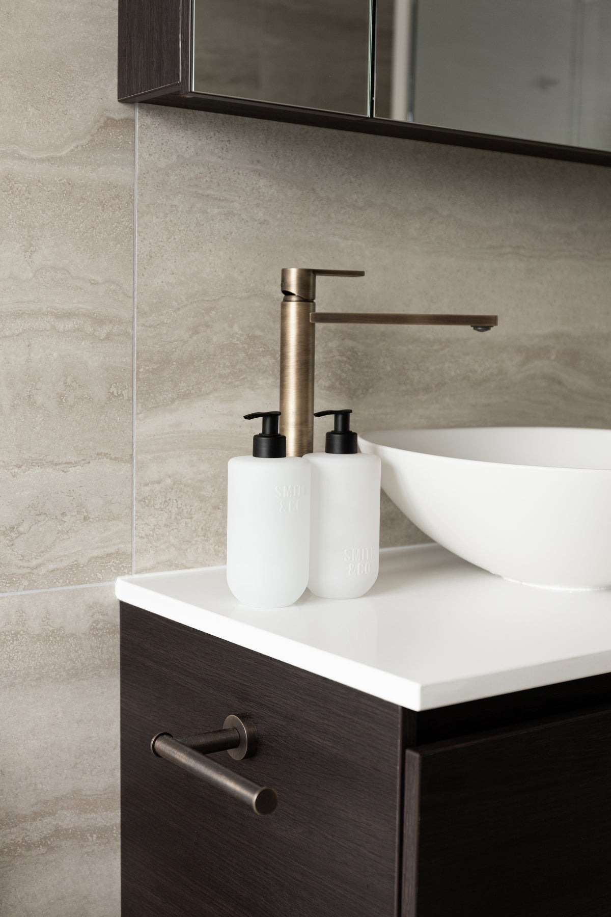 Smith and Co bottles beside a vessel basin on a dark timber vanity