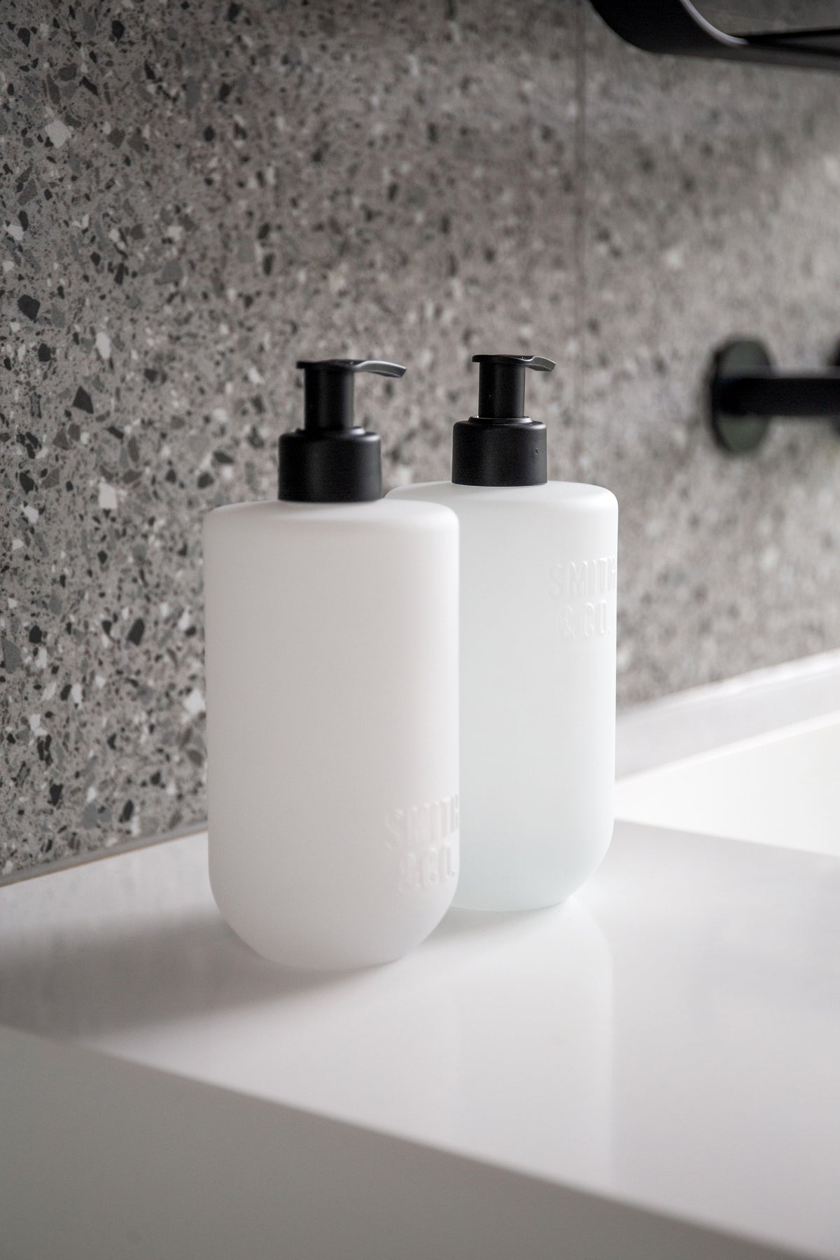 Smith and Co wash and lotion on a white benchtop against a terrazzo wall